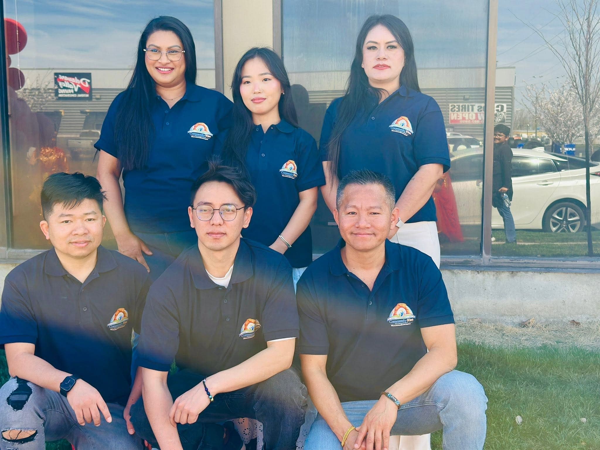The Community Rise Foundation team outdoors in navy shirts carrying the Foundation logo