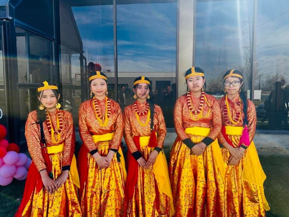 Five young dancers in red and gold Nepali costume with beaded necklaces and headpieces